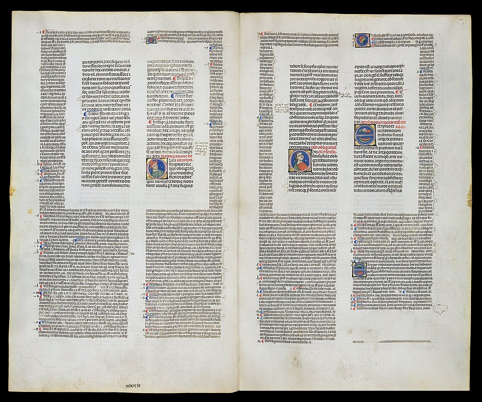 A two-page spread from a 13th-century manuscript of Justinian's Digestum Vetus with Glossa Ordinaria. The central text block is surrounded on all sides by smaller commentary text, with illuminated capitals and rubrics in red ink.